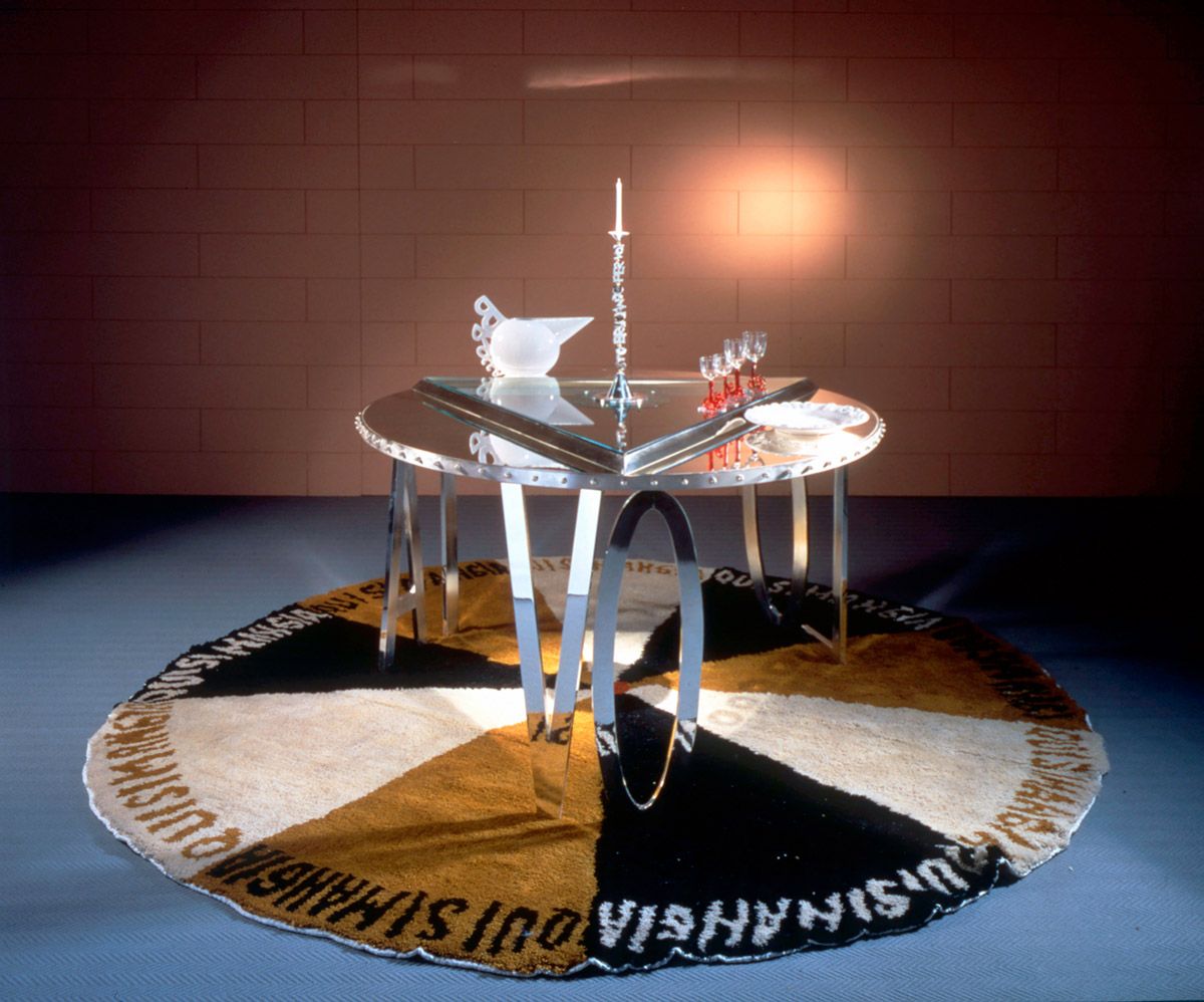 1990_larte-delle-tavola_Luigi-Serafini-Tvlo-letterale_prod-Lapini-piatti-MArioni-bicchiere-sSeguso-tappeto-textileart.jpg